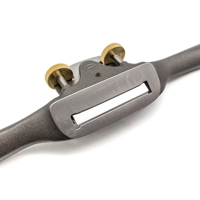 Close-up of the Melbourne Tool Company Spokeshave, showcasing its sleek metal body and two intricately designed brass adjustment knobs, ideal for precision woodworking.