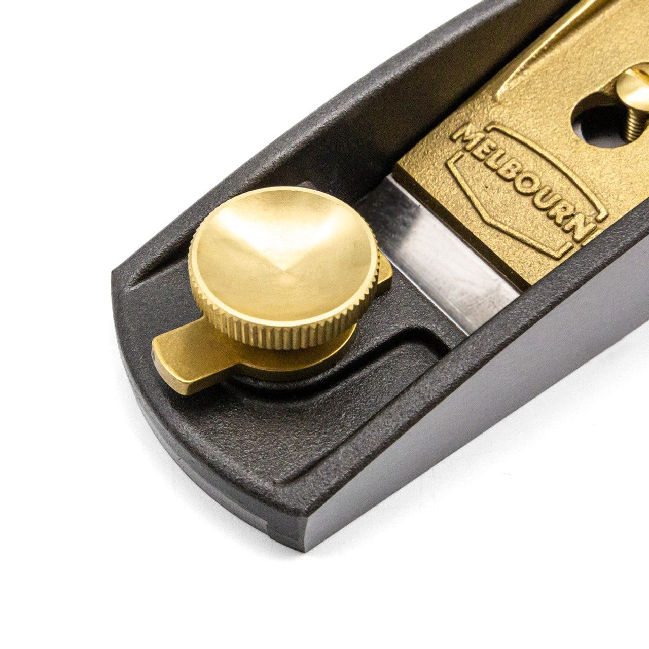 A close-up view of an adjustable brass mechanism on a Low Angle Block Plane, engraved with "Melbourne Tool Company," highlights precision in blade adjustment.