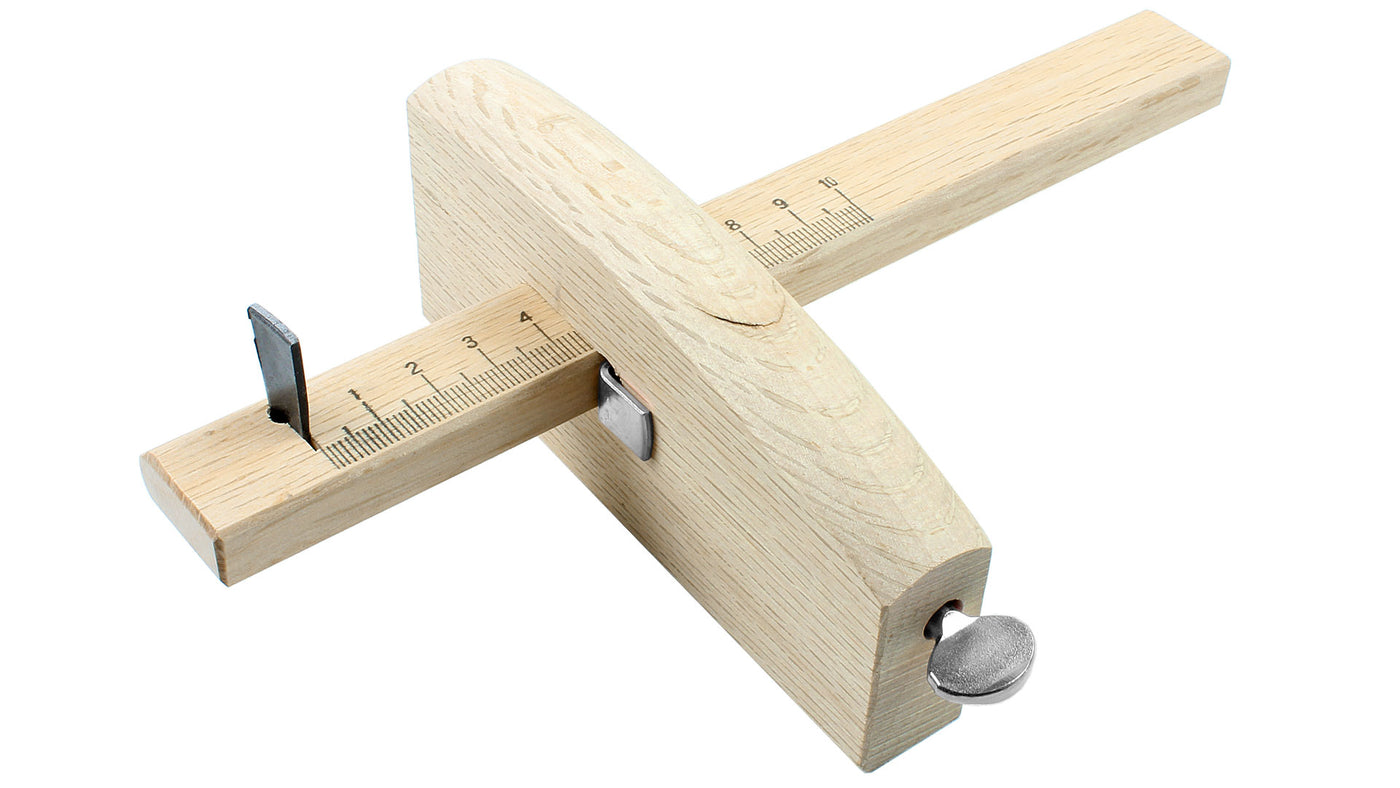 The MARU Japanese Marking Gauge: Kebiki features a wooden body with a metal adjustment screw and slider, complete with an integrated centimeter ruler for precise measurements. It's the perfect partner to your marking knife and an essential tool for any woodworking enthusiast.