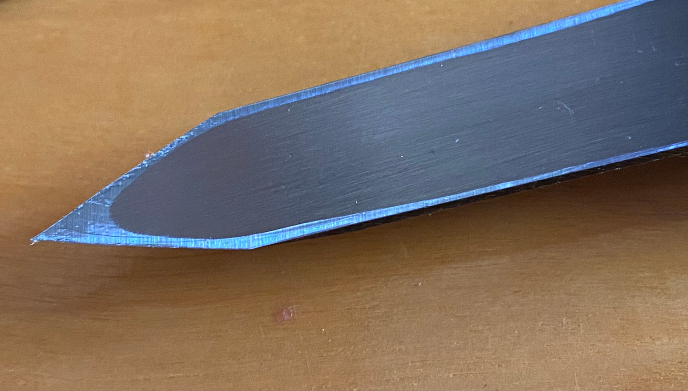 Close-up of the Ikeuti Japanese Marking Knife by MARU, featuring a sharp laminated steel blade, placed on a wooden surface.