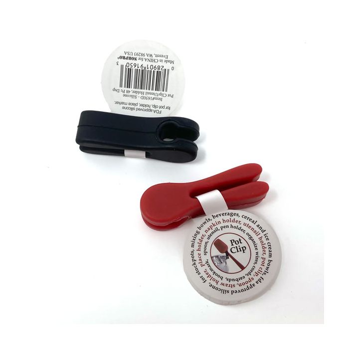 The NORP Grip-Ez Pot Clip in black and red, made from heat-resistant silicone, features a circular tag with a barcode and product details. These clips double as utensil holders and are elegantly displayed against a white background.